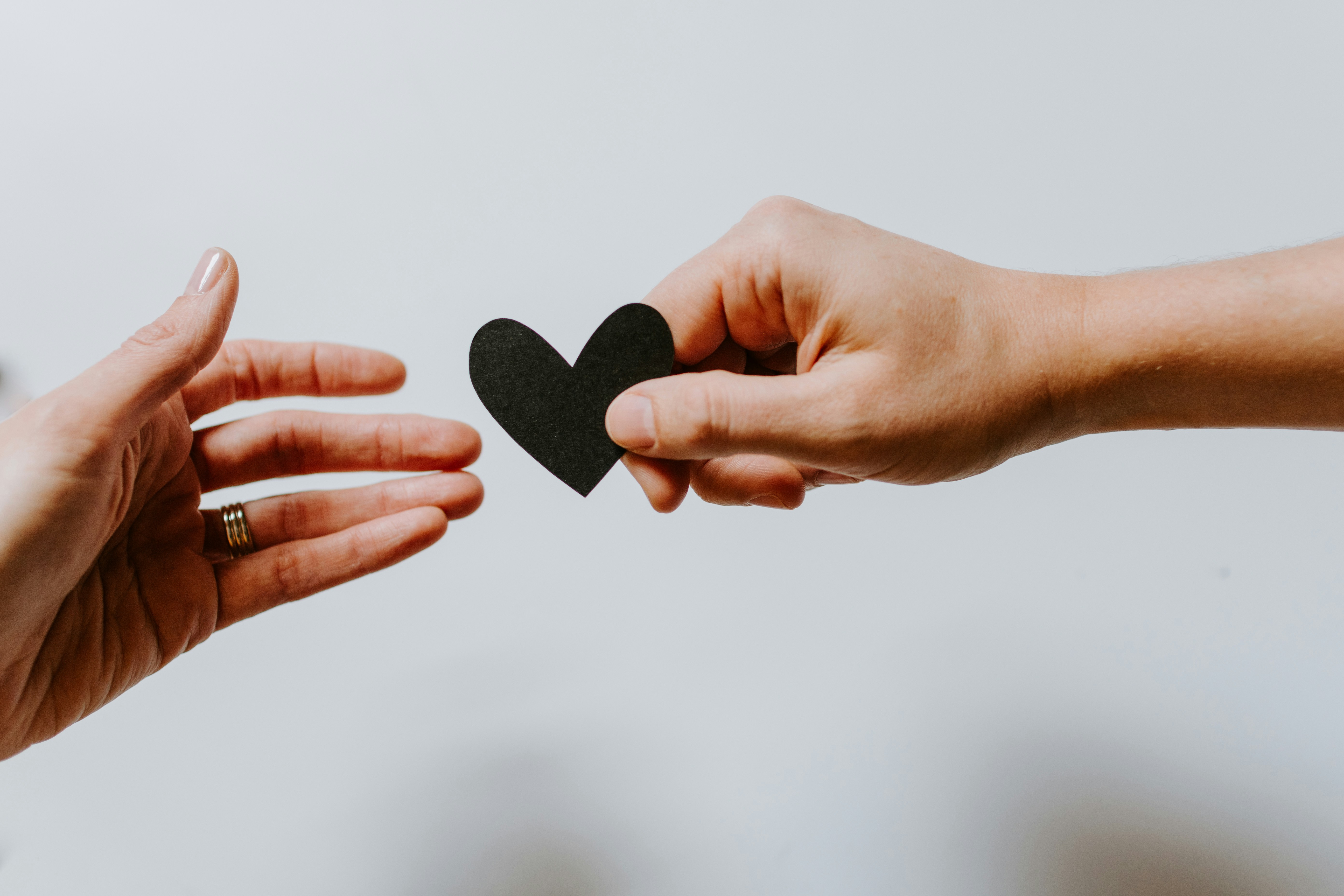 hand handing heart to other hand